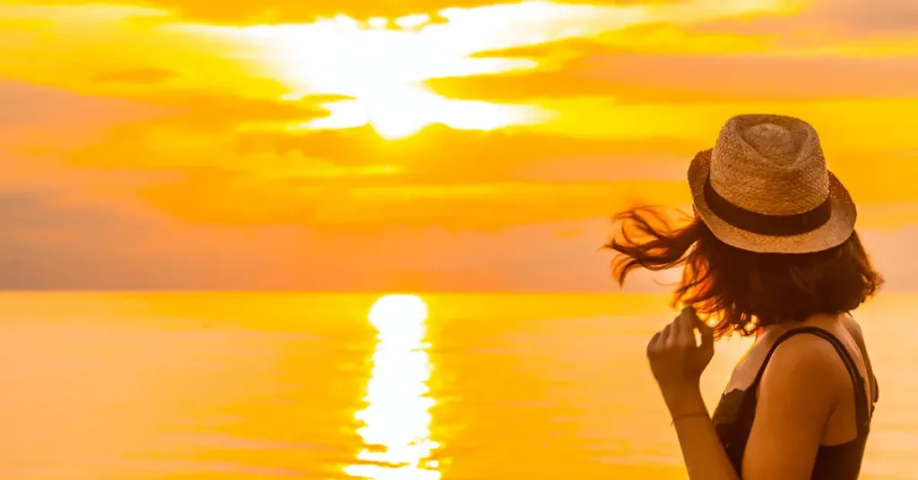 A young woman looks at the sunset in the ferry going to Roatan island