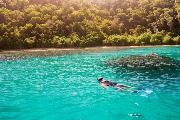 Cayos Cochinos, Honduras A man is snorkeling in the Caribbean Ocean of the Cayos Cochinos islands in Honduras