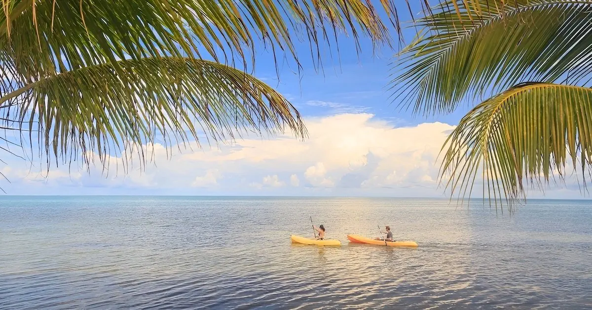 A couple kayaking in the ocean of George Caye in Belize