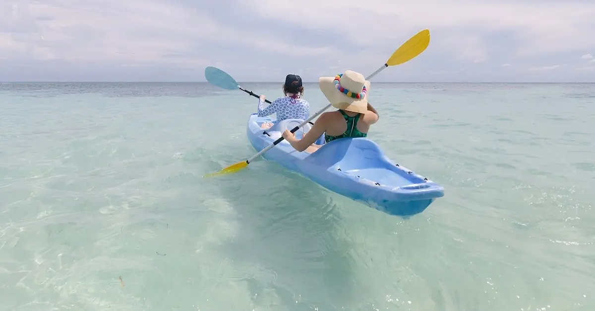Two ladies go kayaking in the crystal clear waters of the Caribbean Ocean of Belize