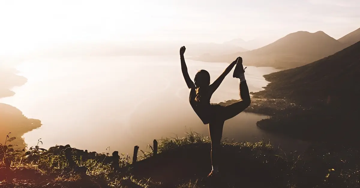 A young woman practices Yoga in the lookout the Rostro Maya lookout in Lake Atitlan during sunrise