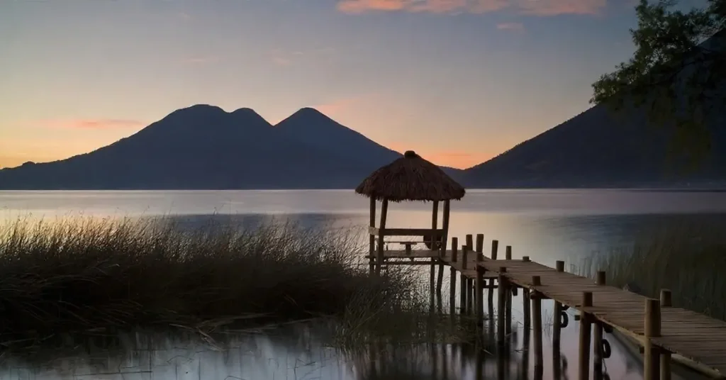 The volcanoes of Lake Atitlan during sunset seeing from a wooden dock