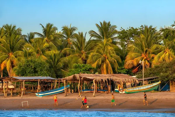 Young man are playing football in the Bay Jiquilisco of El Salvador
