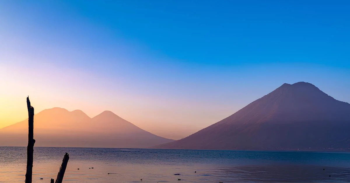 The volcanoes in Lake Atitlan during sunrise in a blue sky day
