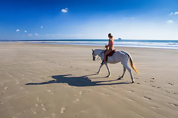 Playa Hermosa, Nicaragua A young woman is horseback riding in the Hermosa beach during a sunny day in Nicaragua
