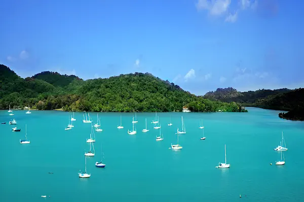 Various white sailing boats in the Caribbean harbor of Portobelo in Panama