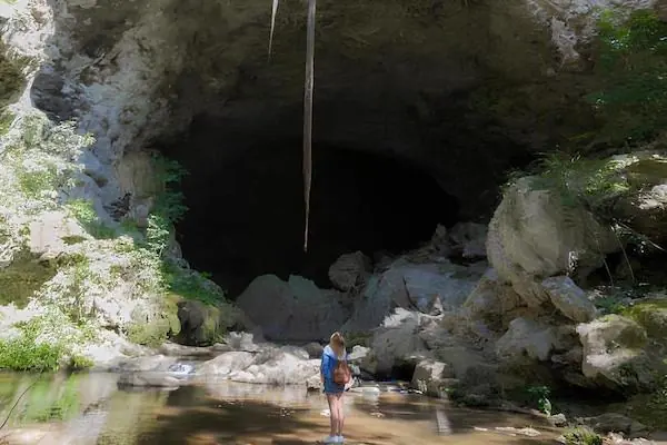 Rio Frio Cave, Belize A young woman is standing at the entrance of Rio Frio Cave while looking up
