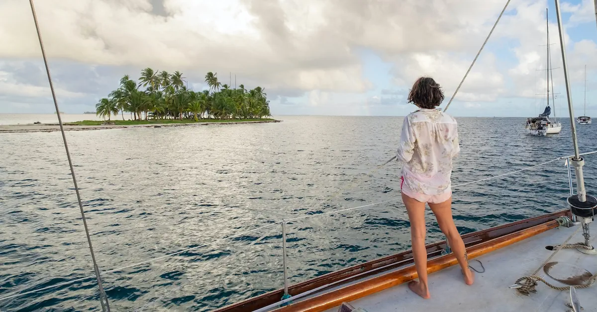 A woman is looking at the of the uninhabited islands of San Blas from her sailing boat