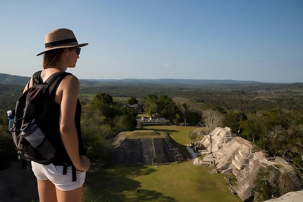 Xunantunich, Belize A young tourist is standing at the top of the pyramid El Castillo in the Mayan ruins of Xunantunich