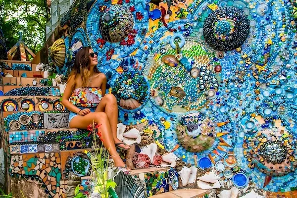 A young woman is sitting in a stairs with a mosaic of colors in Utila Honduras