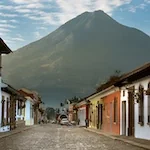One of the cobblestone streets of Antigua Guatemala with the imposing volcano de Agua in the background