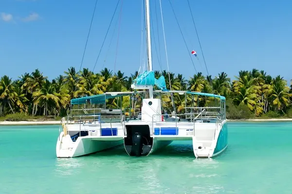 A Catamaran boat approaching a small island in the Caribbean Sea