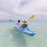 Two women are kayaking in the crystal clear waters of the Caribbean Ocean of Belize