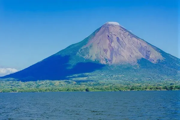 The towering peak of the Concepcion Volcano rising above the lush green landscape and calm waters of Ometepe Island, Nicaragua.