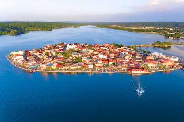 Aerial view of the dense, red-roofed town on Flores Island surrounded by Lake Petén Itzá, Guatemala.